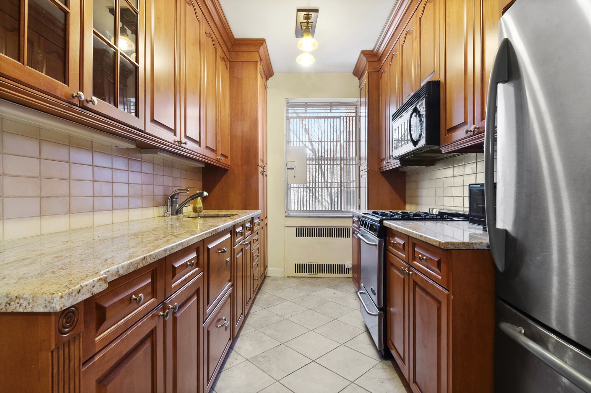 1615 Avenue I, Unit 603 Brooklyn, NY 11230 - Photo 5 of 13 a kitchen with stainless steel appliances granite countertop a stove a sink and a refrigerator