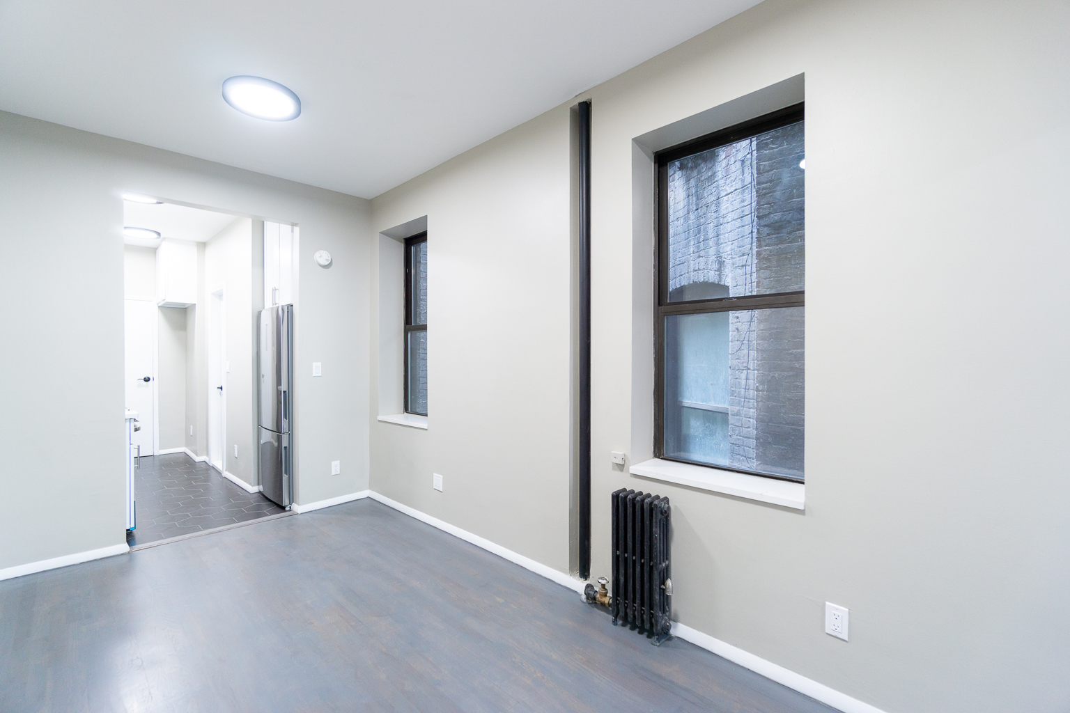 338 East 5th Street, Unit 5 Manhattan, NY 10003 - Photo 4 of 11 a view of an empty room with wooden floor and a window