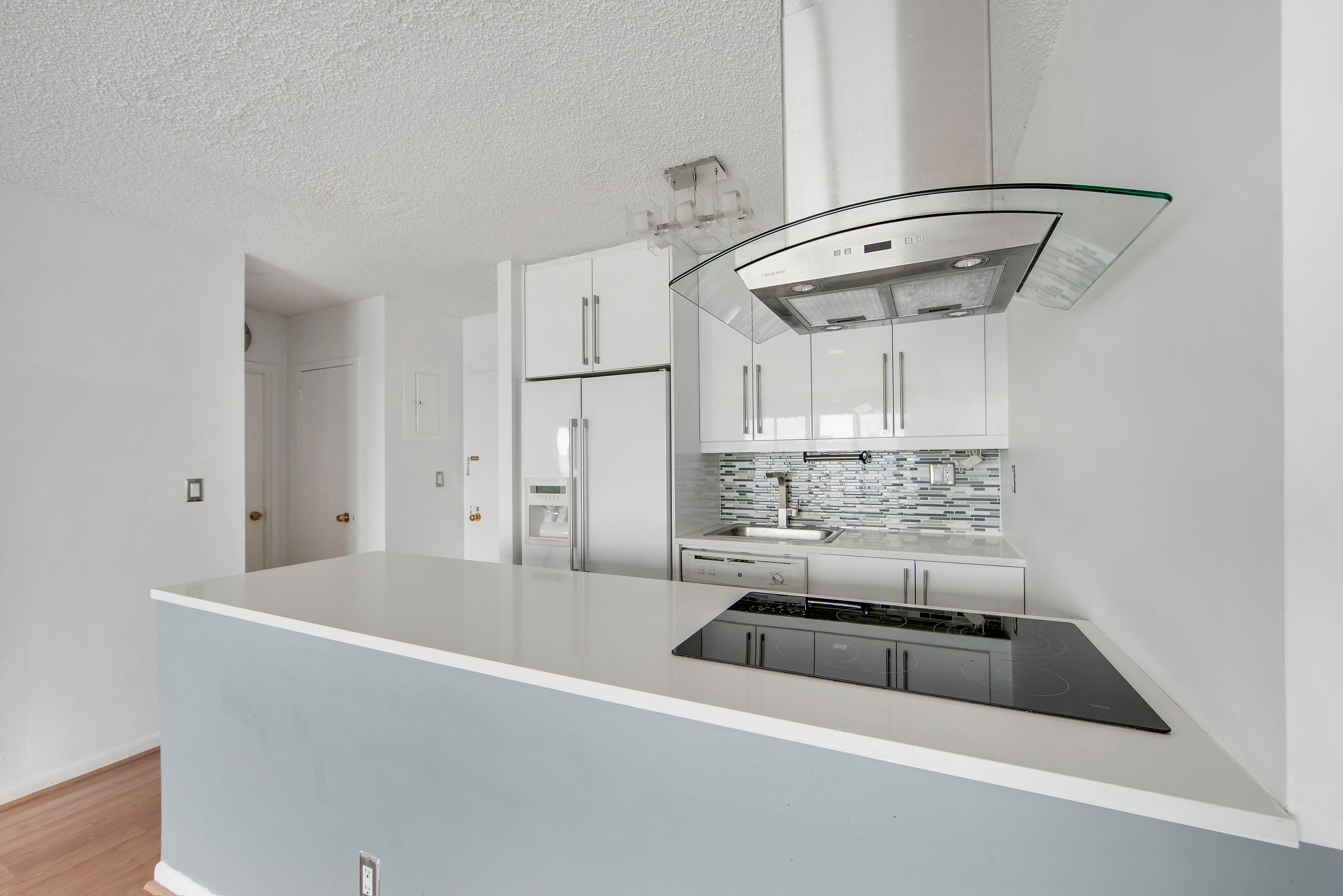 25-40 Shore Boulevard, Unit 15S Queens, NY 11102 - Photo 9 of 21 a kitchen with a sink a stove and cabinets