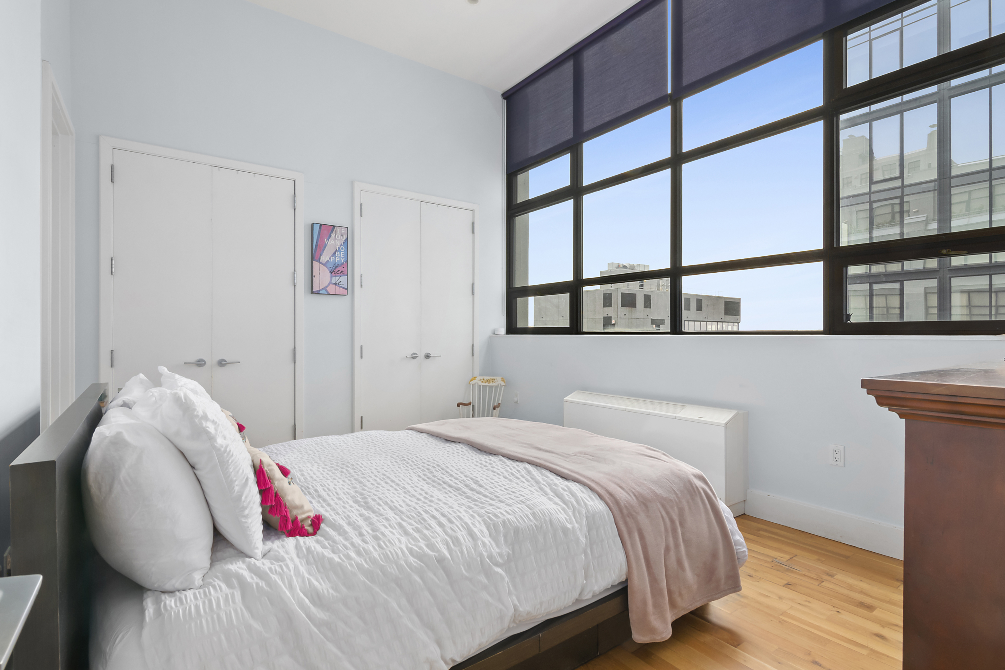 360 Furman Street, Unit 1036 Brooklyn, NY 11201 - Photo 5 of 45 a bedroom with a bed and a painting on the wall