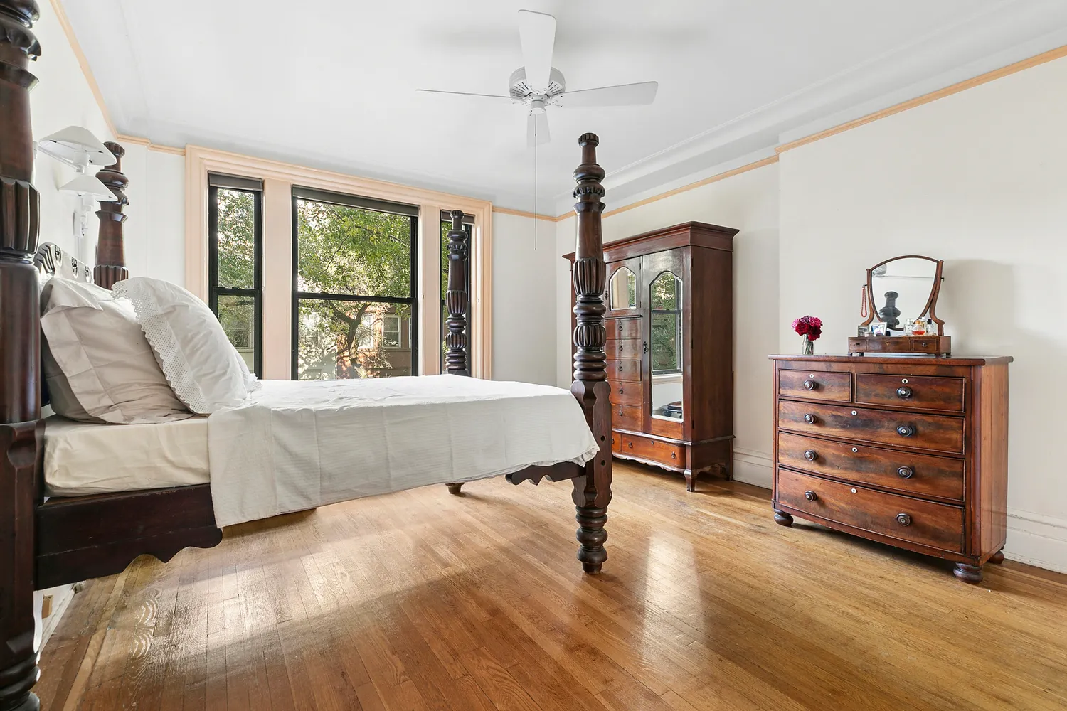 a spacious bedroom with a bed a dresser and a window