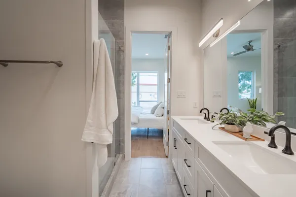 a spacious en suite bathroom with a double vanity sink and mirror