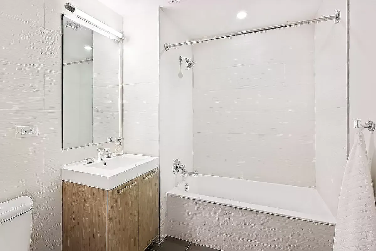 26-14 Jackson Avenue, Unit 9BB Queens, NY 11101 - Photo 4 of 8 a bathroom with a bathtub a sink and a shower