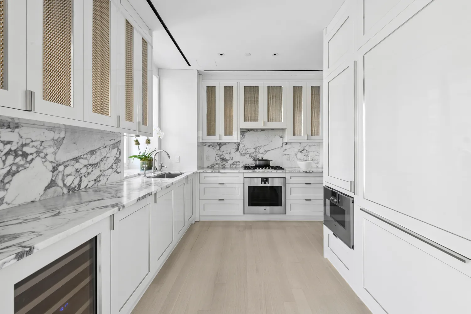 a kitchen with stainless steel appliances kitchen island granite countertop white cabinets and window