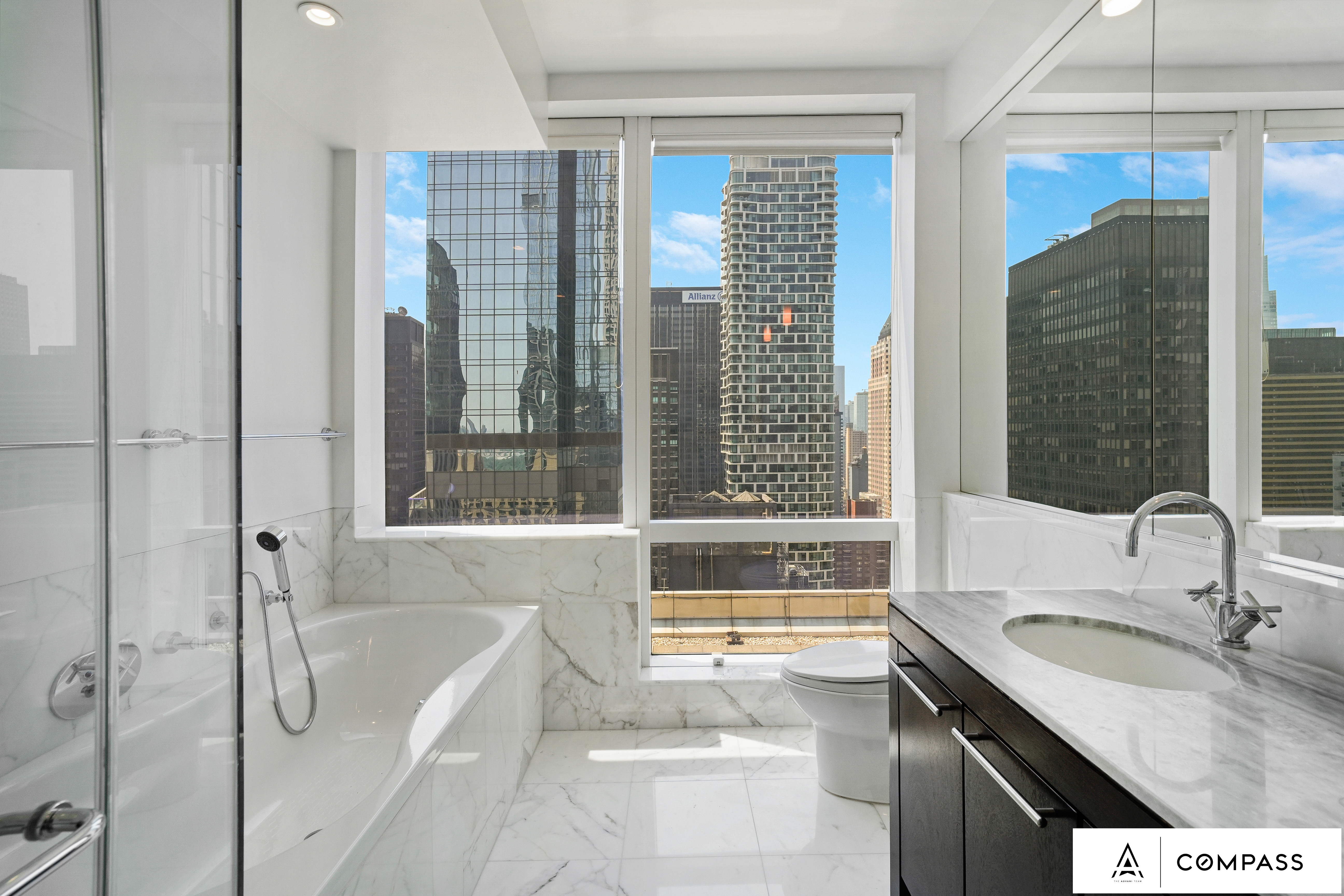 230 West 56th Street, Unit 49C Manhattan, NY 10019 - Photo 7 of 14 a bathroom with a granite countertop sink and a large mirror