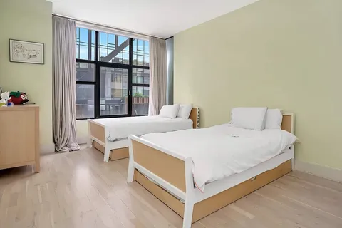 a bedroom with a bed and a large window