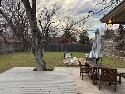 a view of a wooden chairs and table in the patio