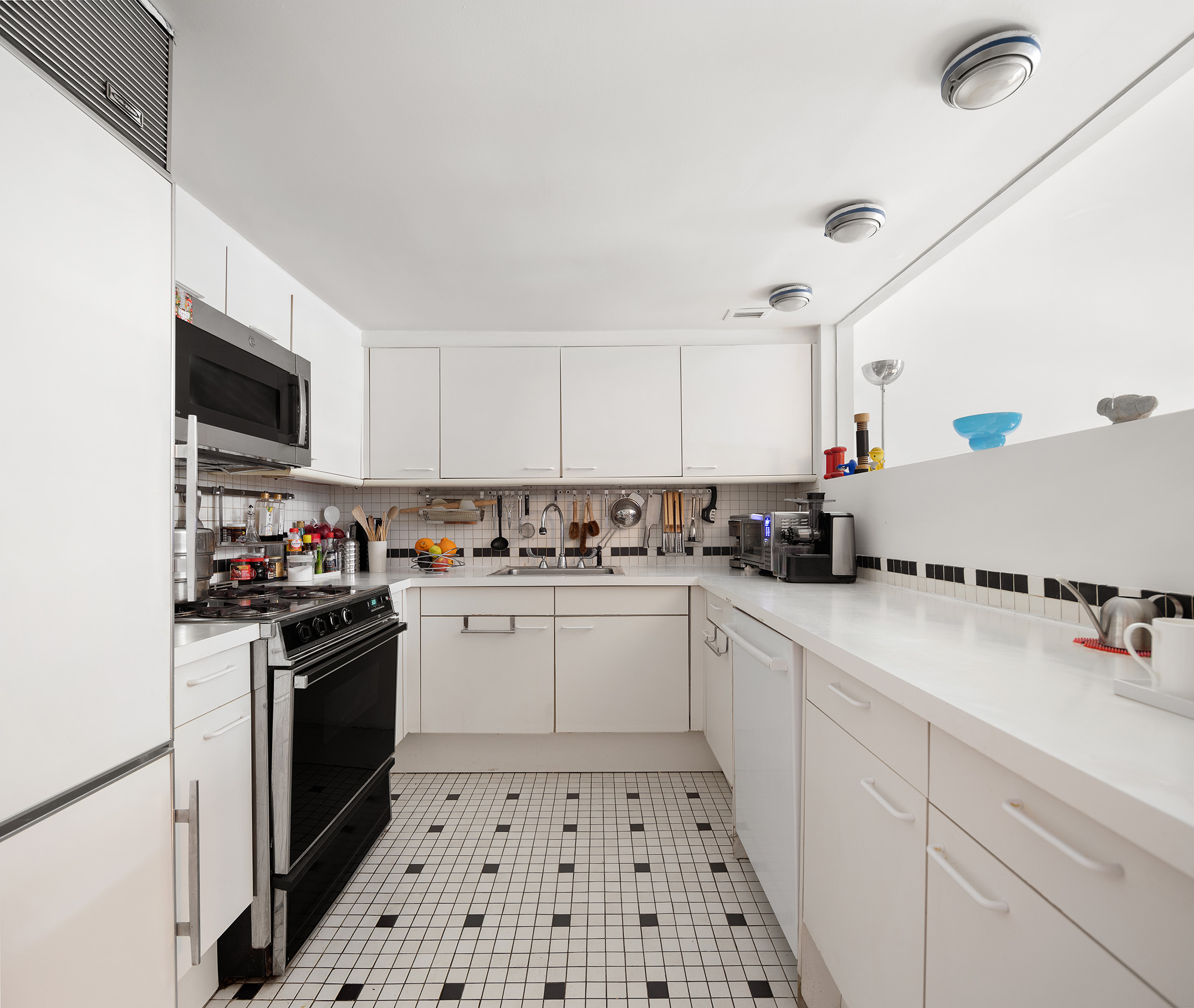 240 Centre Street, Unit 2B Manhattan, NY 10013 - Photo 10 of 12 a kitchen with a sink a stove and cabinets