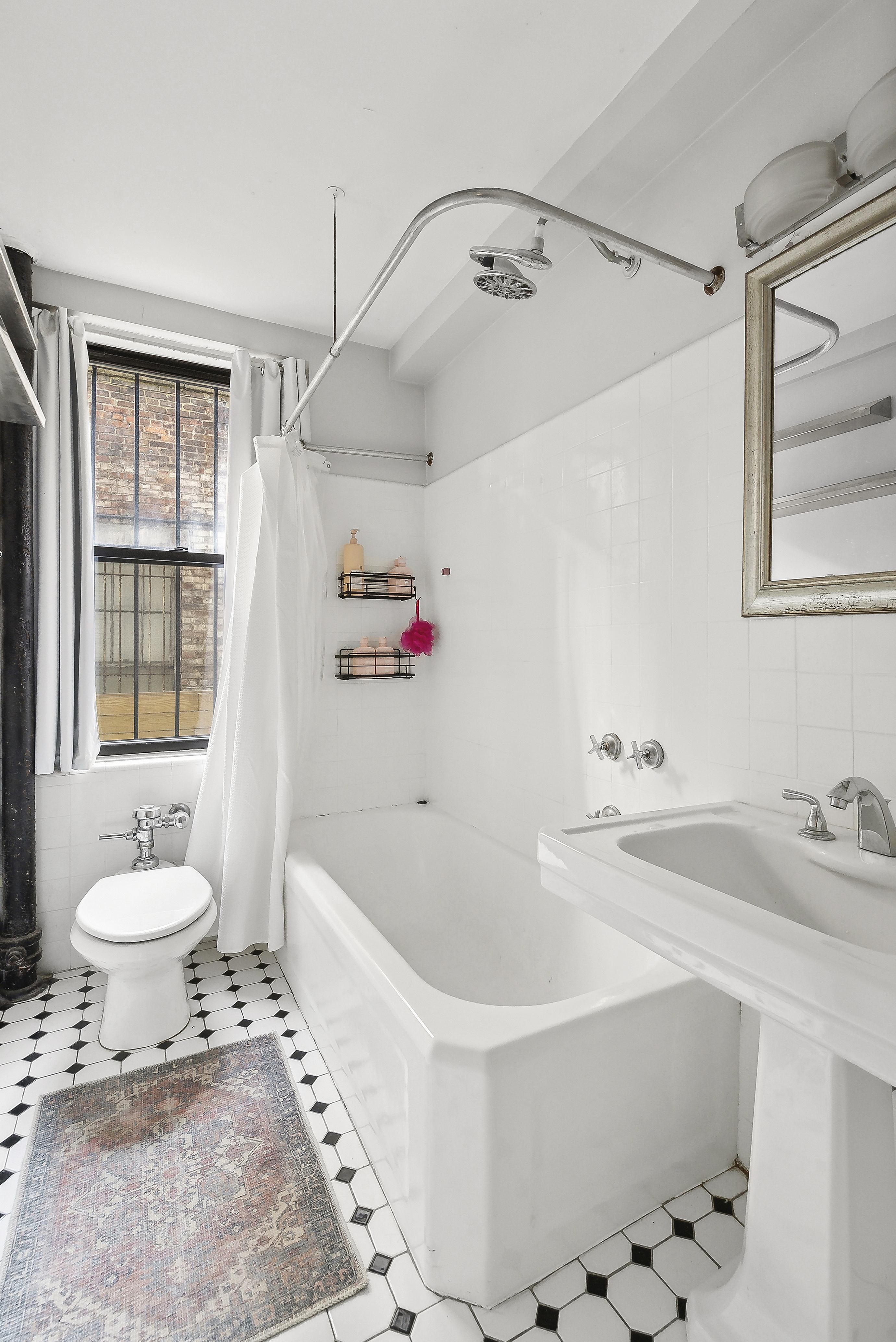 235 East 73rd Street, Unit 1D Manhattan, NY 10021 - Photo 7 of 13 a bathroom with a sink toilet and shower
