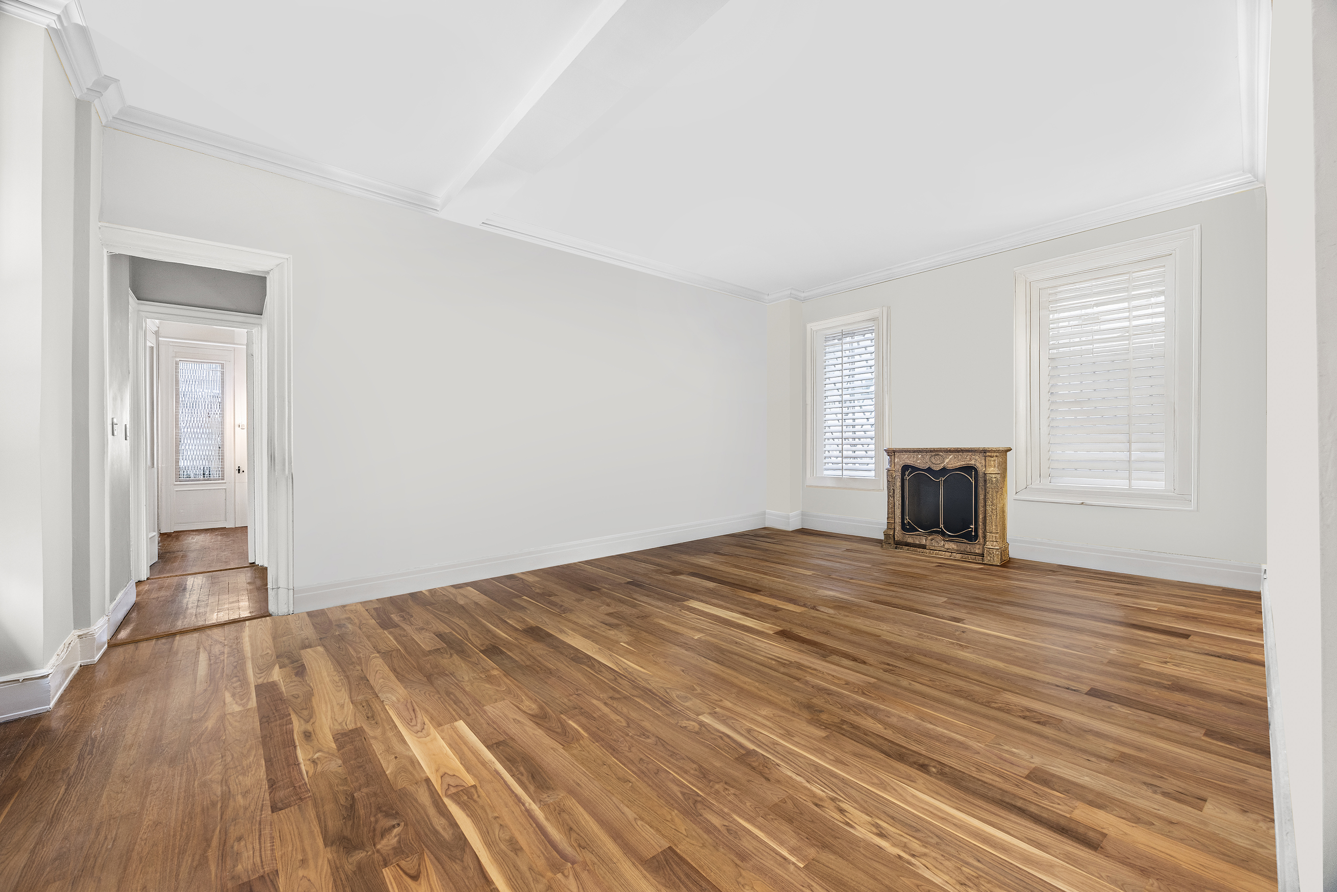a view of empty room with wooden floor and fireplace