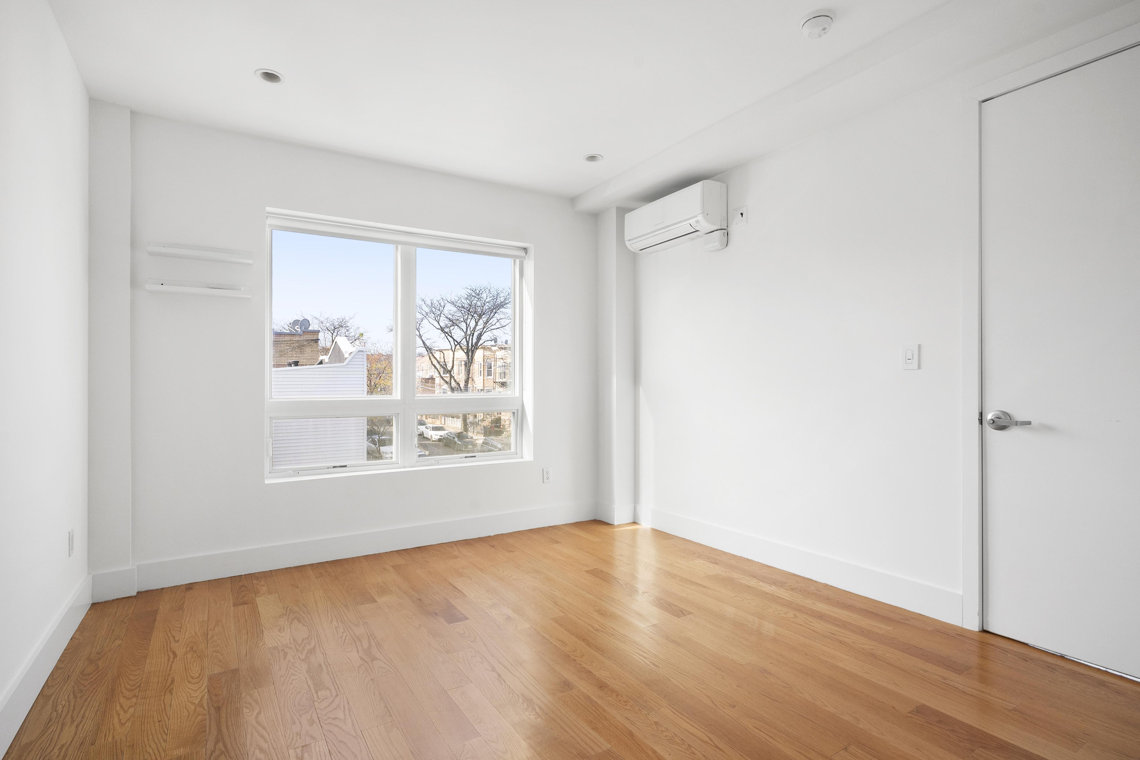 63-34 Fresh Pond Road, Unit 3D Queens, NY 11385 - Photo 5 of 14 a view of an empty room with wooden floor and a window