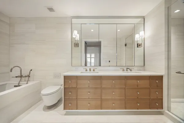 a bathroom with a sink a toilet and a large mirror