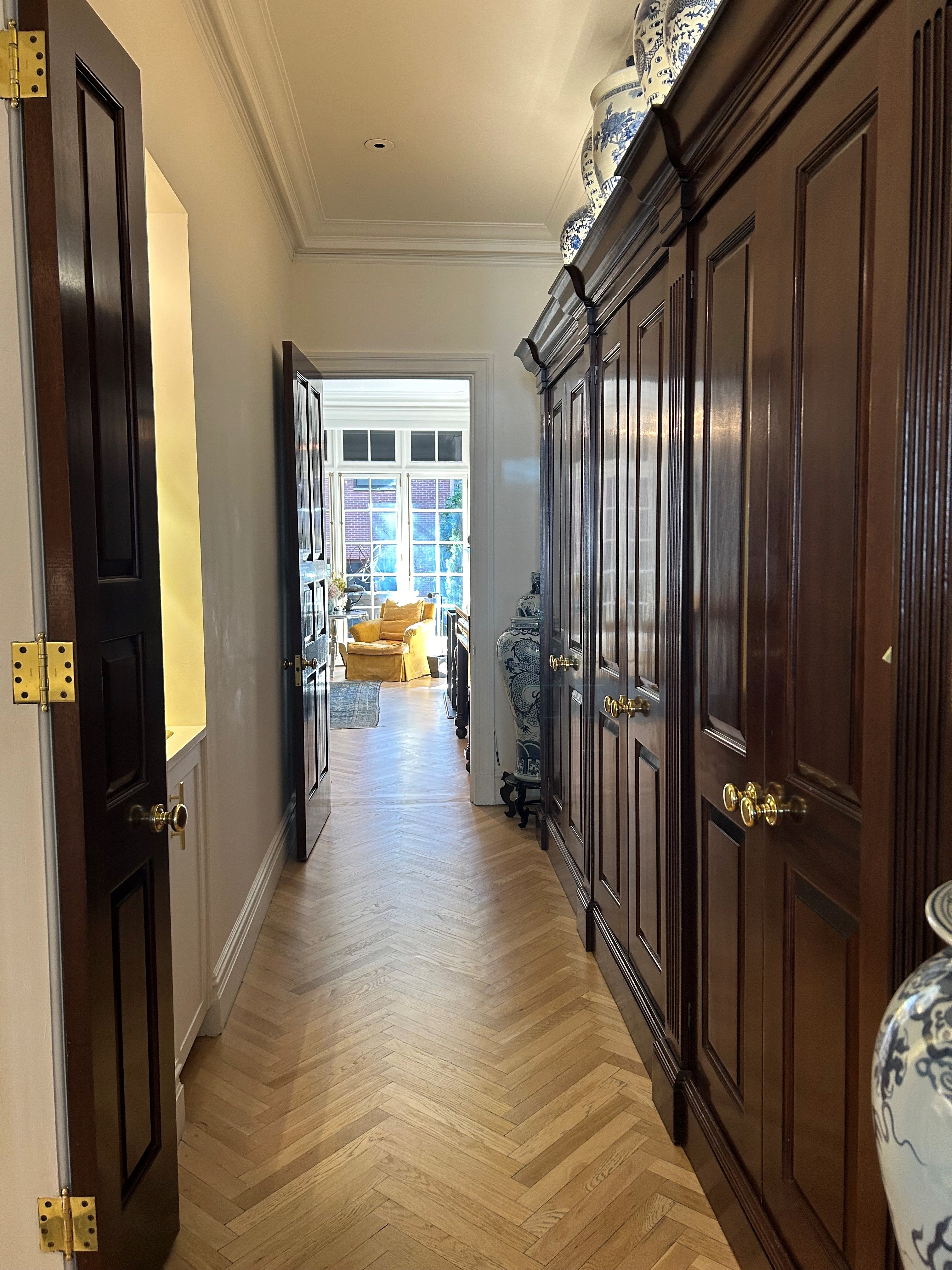 36 East 69th Street, Unit 2AB Manhattan, NY 10021 - Photo 20 of 26 a view of a hallway with wooden walls and stairs