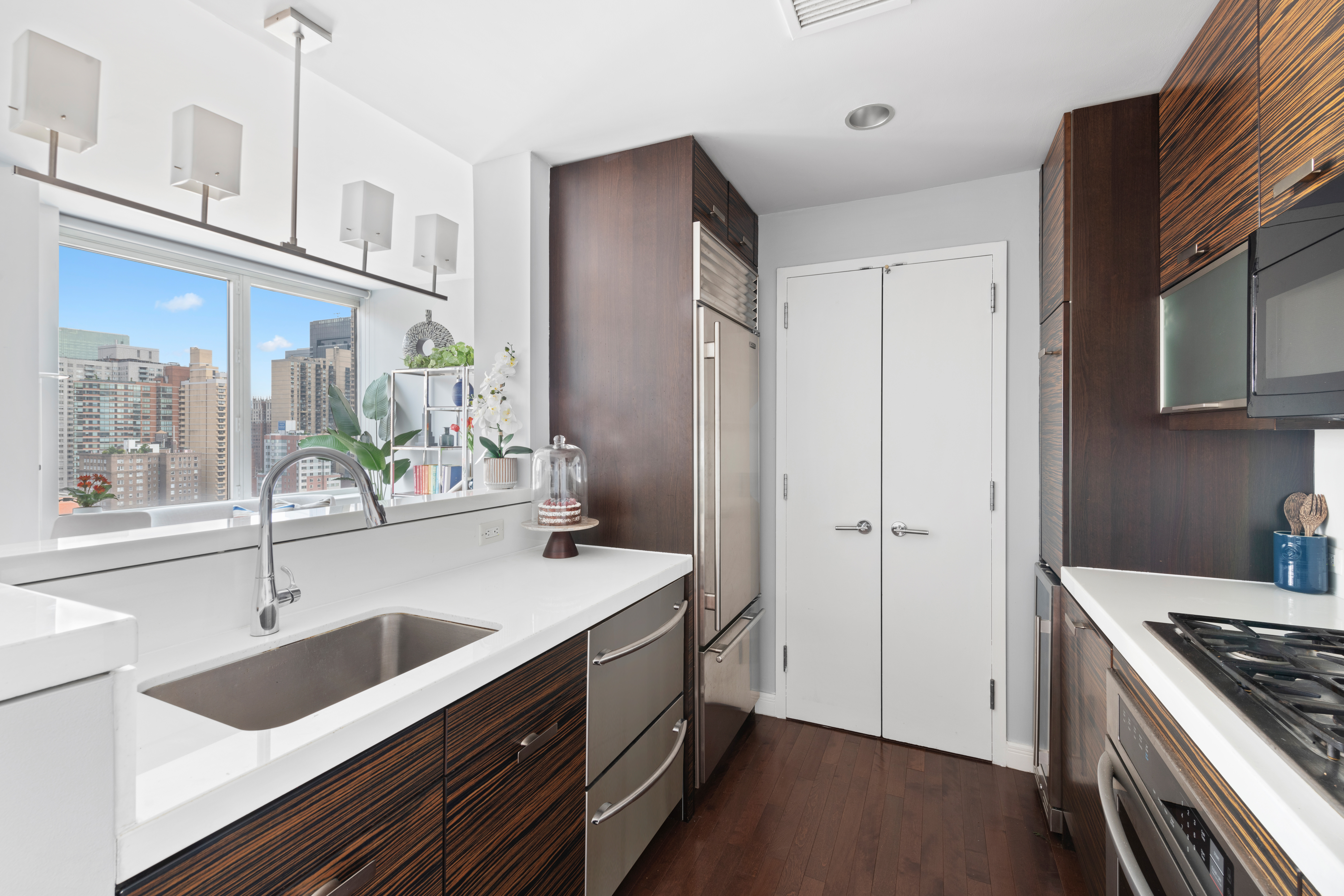 225 East 34th Street, Unit 21I Manhattan, NY 10016 - Photo 6 of 24 a kitchen with a sink stove top oven and refrigerator