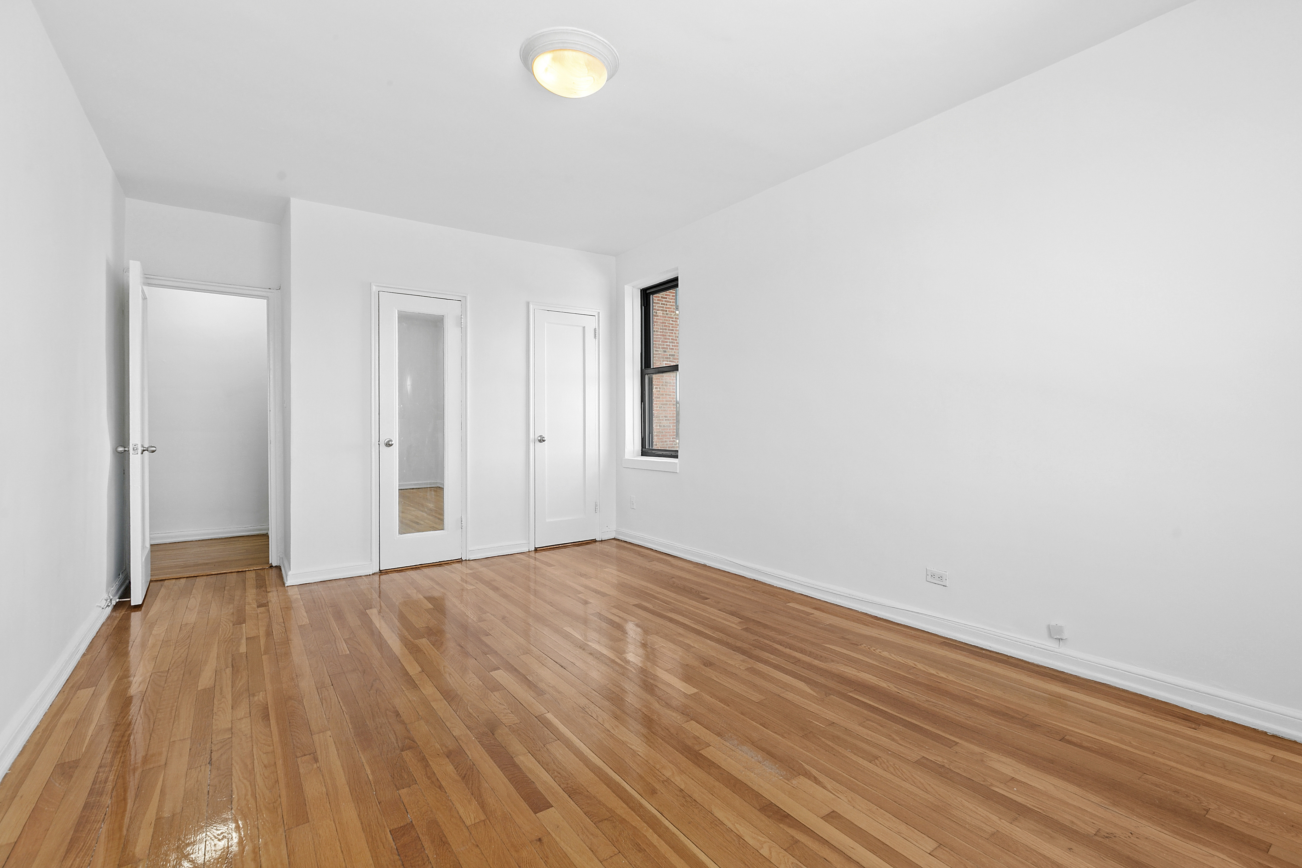 159-00 Riverside Drive West, Unit 4L70 Manhattan, NY 10032 - Photo 6 of 18 a view of empty room with wooden floor