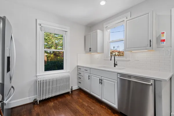 a kitchen with a sink window and cabinets