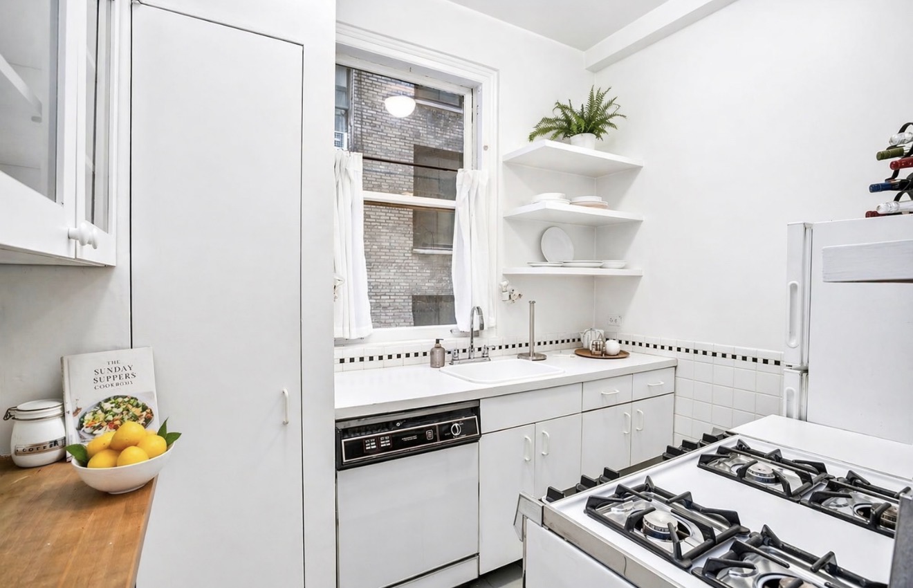 1060 Park Avenue, Unit 3A Manhattan, NY 10128 - Photo 3 of 11 a white kitchen with a stove a sink and a window
