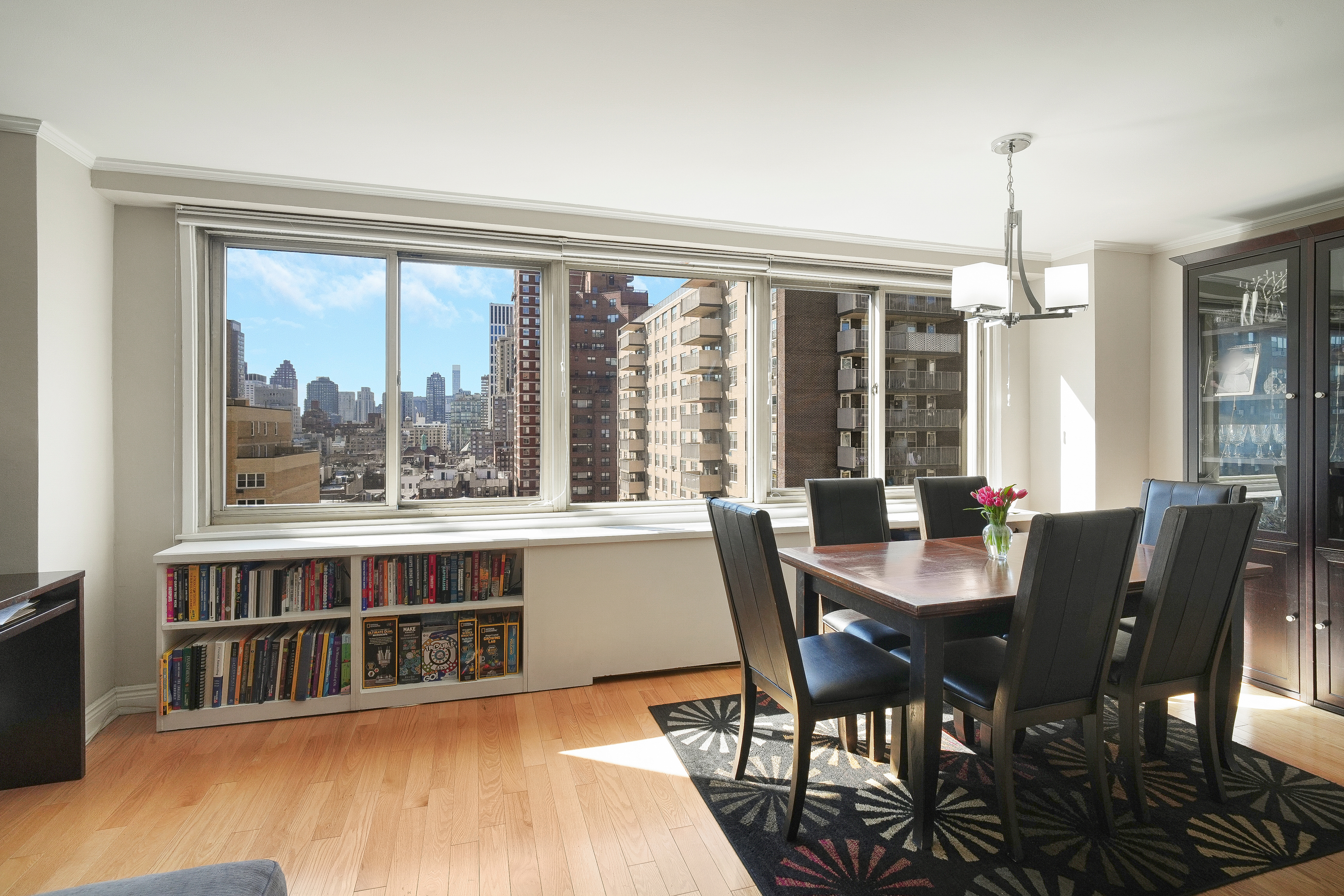 401 East 86th Street, Unit 15C Manhattan, NY 10028 - Photo 1 of 14 a view of a dining room with furniture large windows and wooden floor