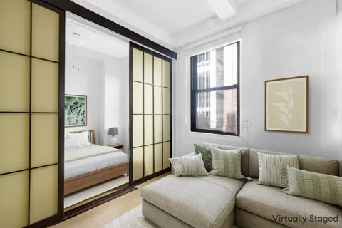 a bedroom with a large bed and a couch next to a window