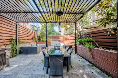 a view of a patio with a table and chairs and potted plants