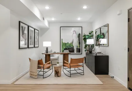a living room with furniture a large window and wood floor