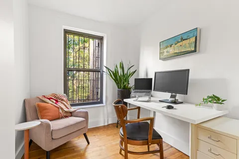 a work room with furniture wooden floor and a window