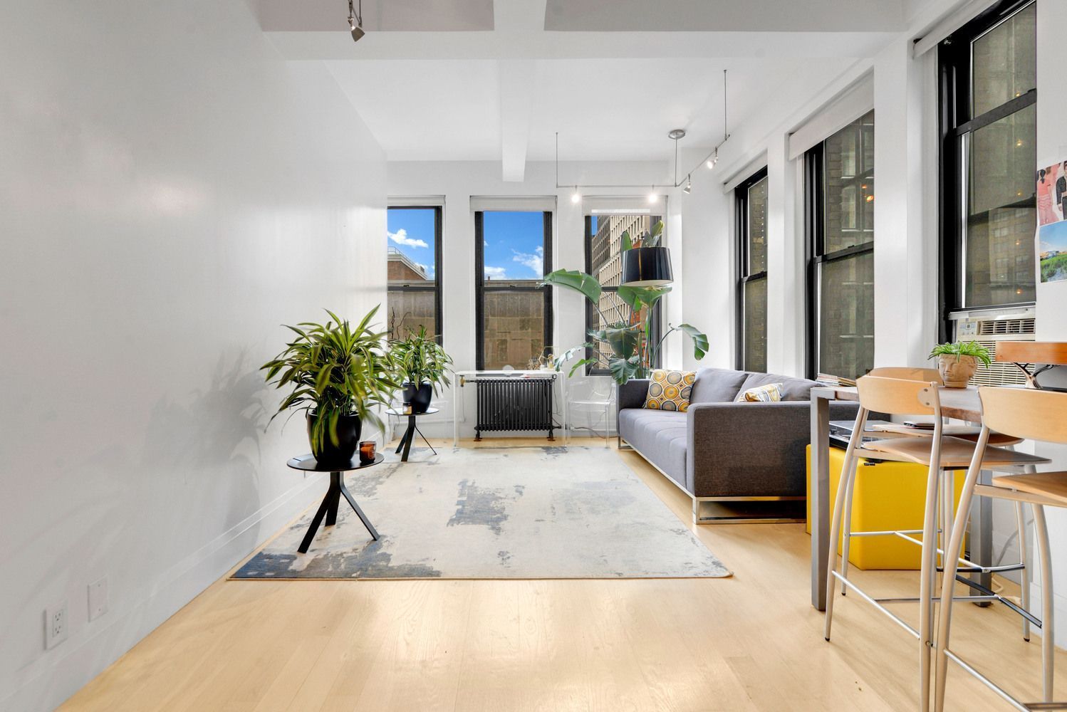 315 7th Avenue, Unit 6A Manhattan, NY 10001 - Photo 2 of 10 a living room with furniture a large window and potted plants