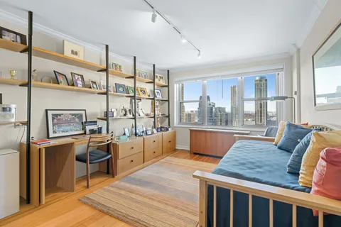 a living room with furniture a large window and kitchen view
