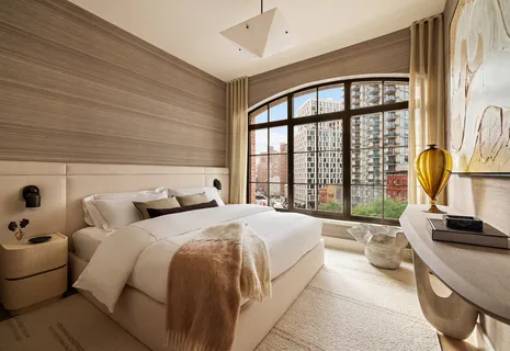 a bedroom with a bed and a large window