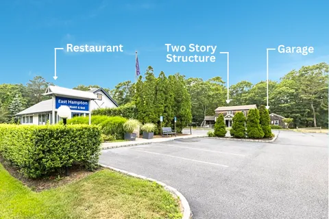 a view of a building with potted plants and a large parking space