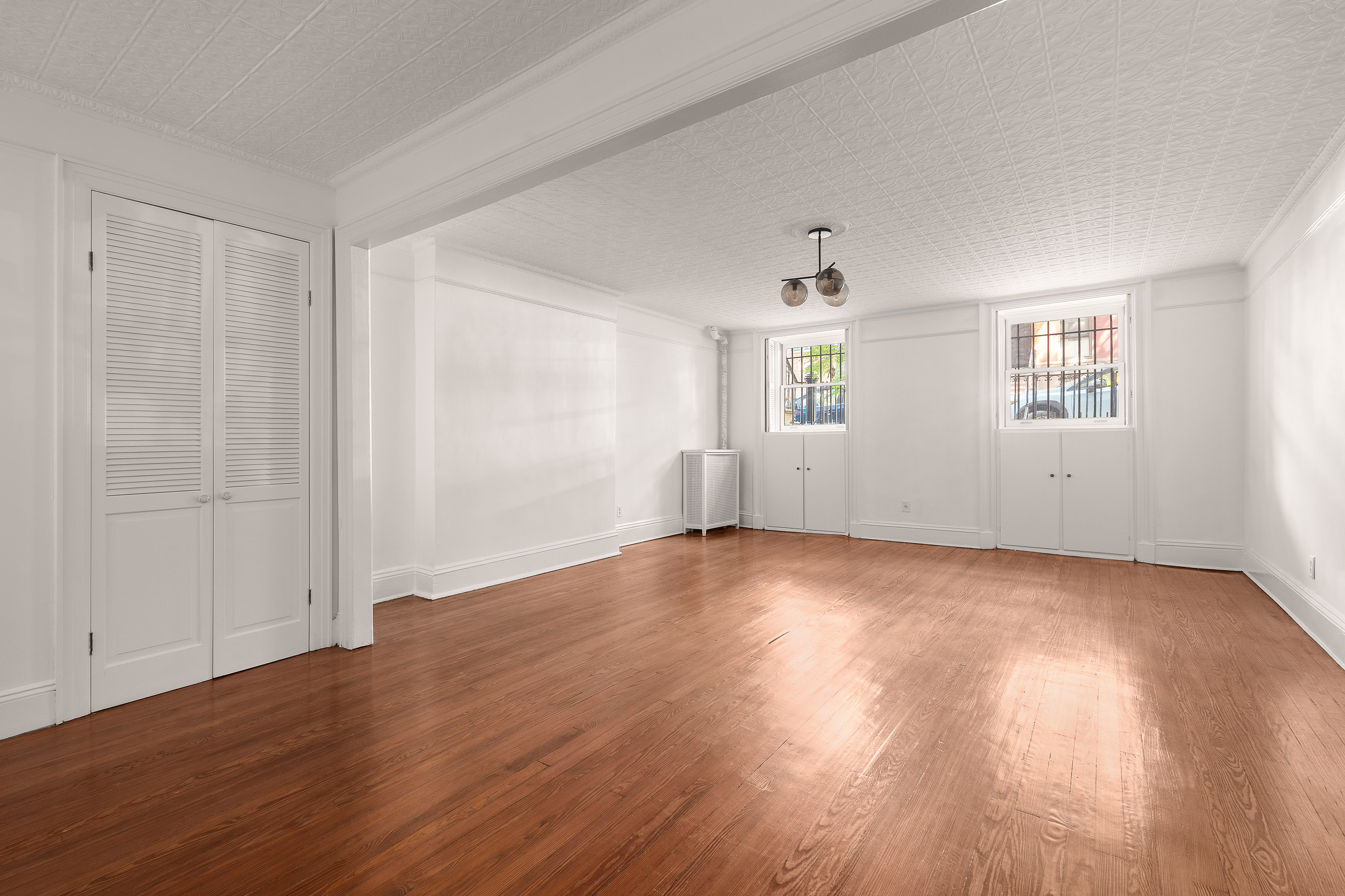176 Warren Street, Unit GARDEN Brooklyn, NY 11201 - Photo 3 of 9 an empty room with wooden floor and windows