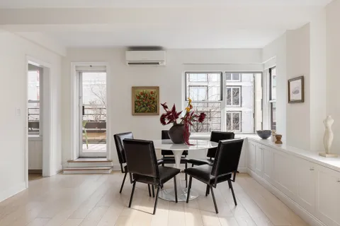 a view of a hallway with wooden floor and furniture