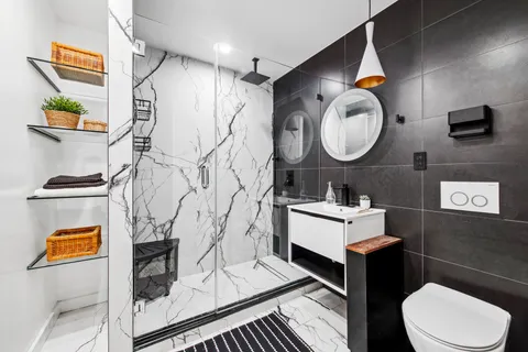 a bathroom with a toilet a sink and mirror