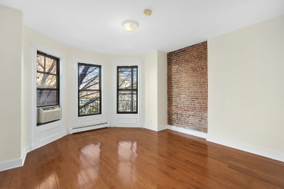 67 Gates Avenue, Unit 2 Brooklyn, NY 11238 - Photo 3 of 4 an empty room with windows & exposed radiator