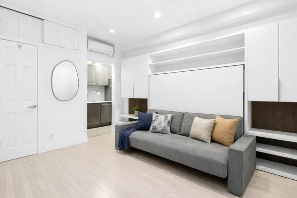a living room with furniture and a mirror