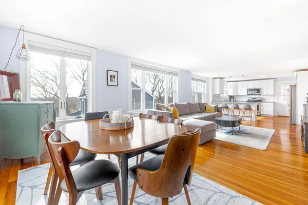 a dining room with furniture a rug and wooden floor