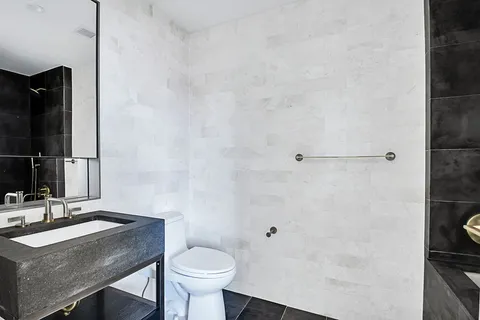 a bathroom with a sink toilet a mirror and shower