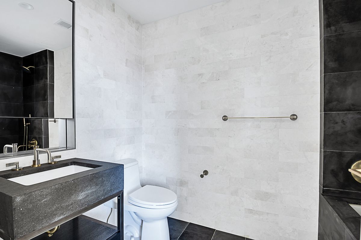1399 Park Avenue, Unit 7B Manhattan, NY 10029 - Photo 10 of 14 a bathroom with a sink toilet a mirror and shower