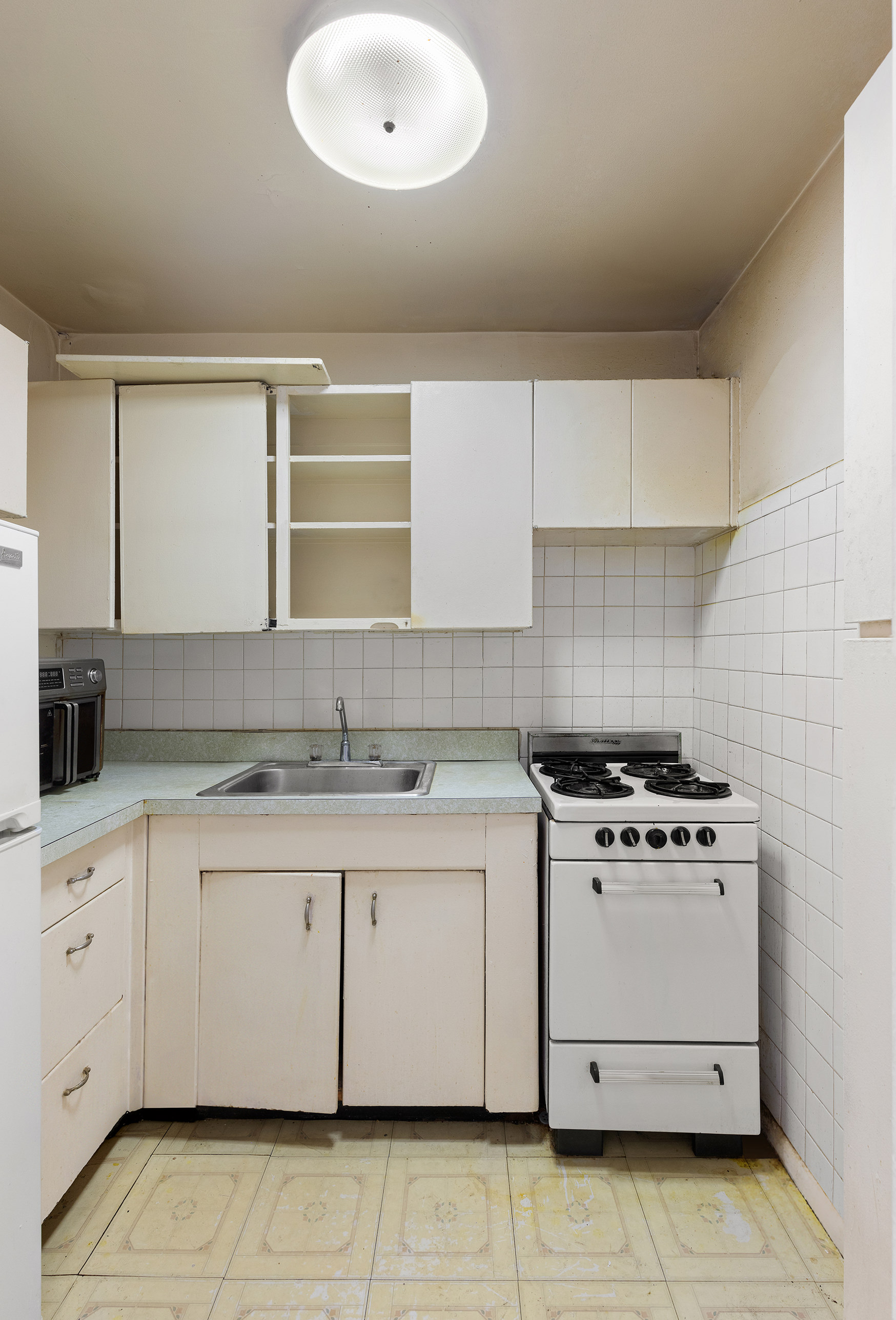 185 Hall Street, Unit 1514 Brooklyn, NY 11205 - Photo 5 of 13 a kitchen with granite countertop a stove sink and cabinets