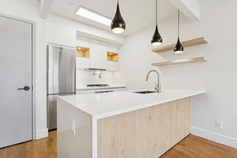 a kitchen with a sink a refrigerator and cabinets