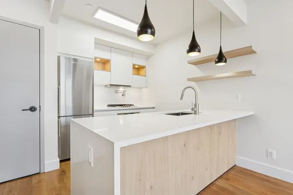 a kitchen with a sink a refrigerator and cabinets