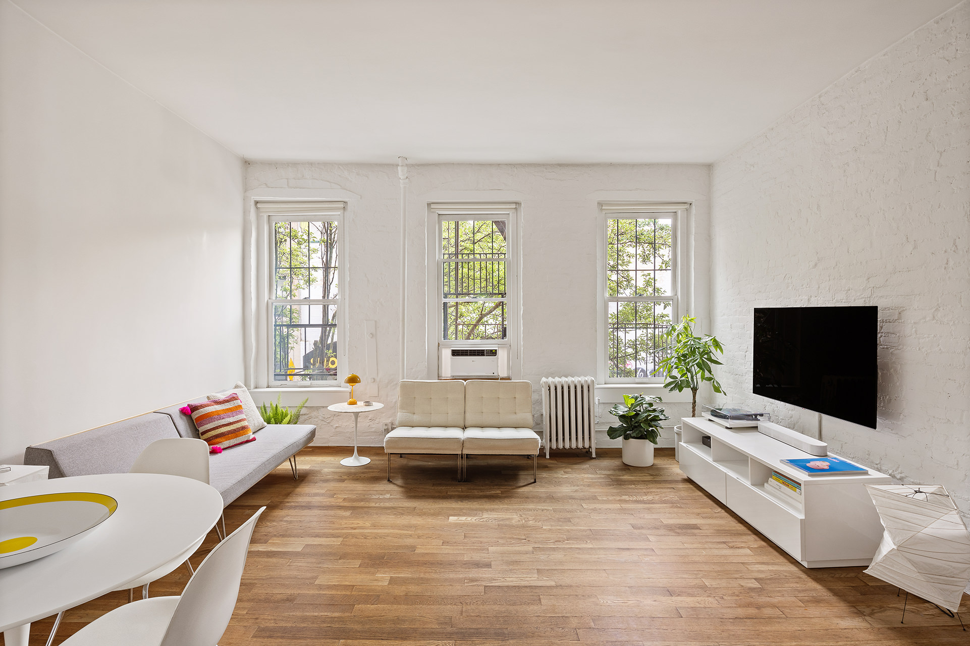 305 East 4th Street, Unit 2 Manhattan, NY 10009 - Photo 1 of 11 a living room with furniture and a flat screen tv
