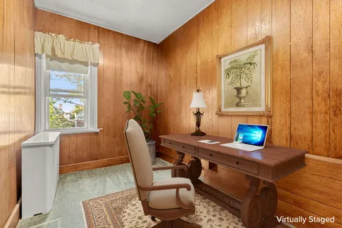 a view of a workspace with furniture and a window