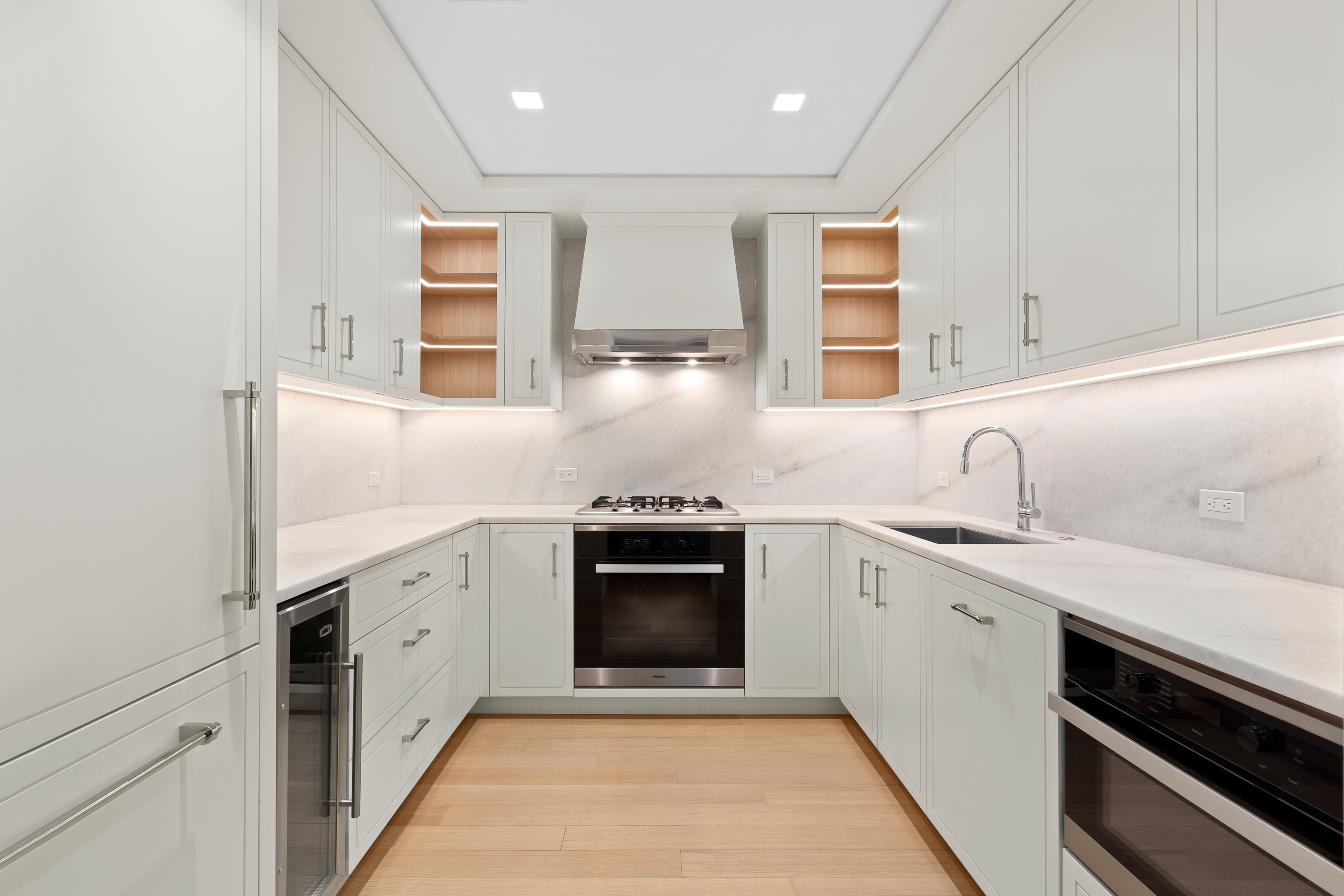 200 East 83rd Street, Unit 5D Manhattan, NY 10028 - Photo 7 of 29 a kitchen with stainless steel appliances granite countertop a sink and dishwasher a stove top oven with wooden floor