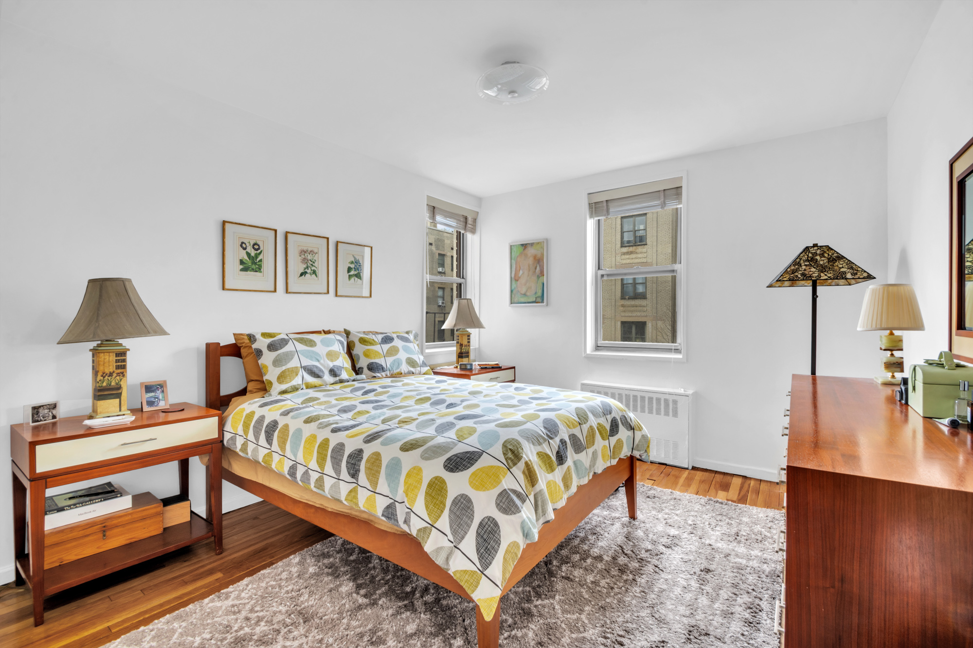 100 Overlook Terrace, Unit 85 Manhattan, NY 10040 - Photo 7 of 8 a bedroom with a bed and a lamp on dresser