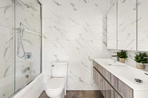 a bathroom with a sink a toilet and shower