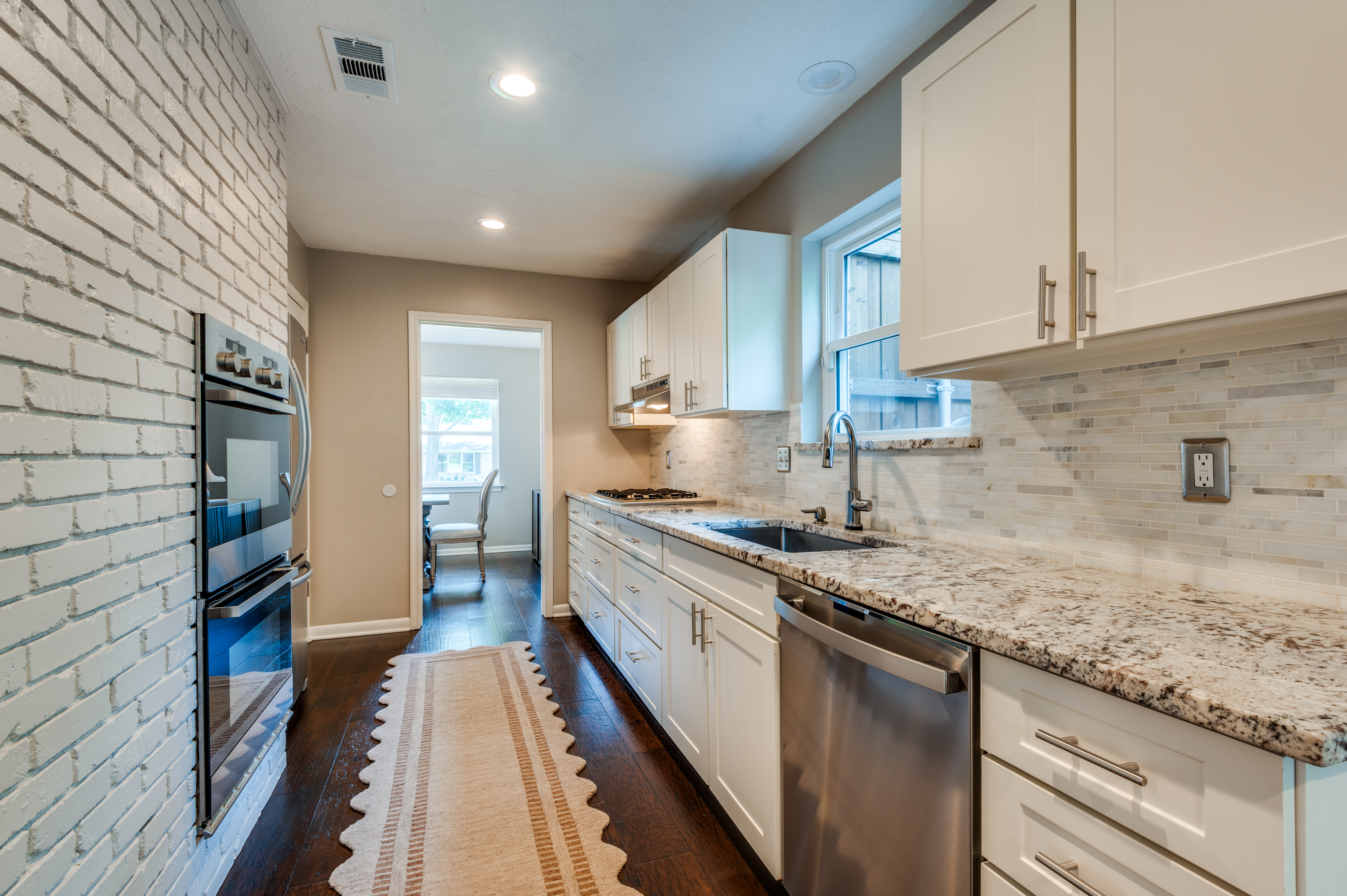 3363 Merrell Road Dallas, TX 75229 - Photo 12 of 29 a kitchen with stainless steel appliances granite countertop a sink stove and cabinets