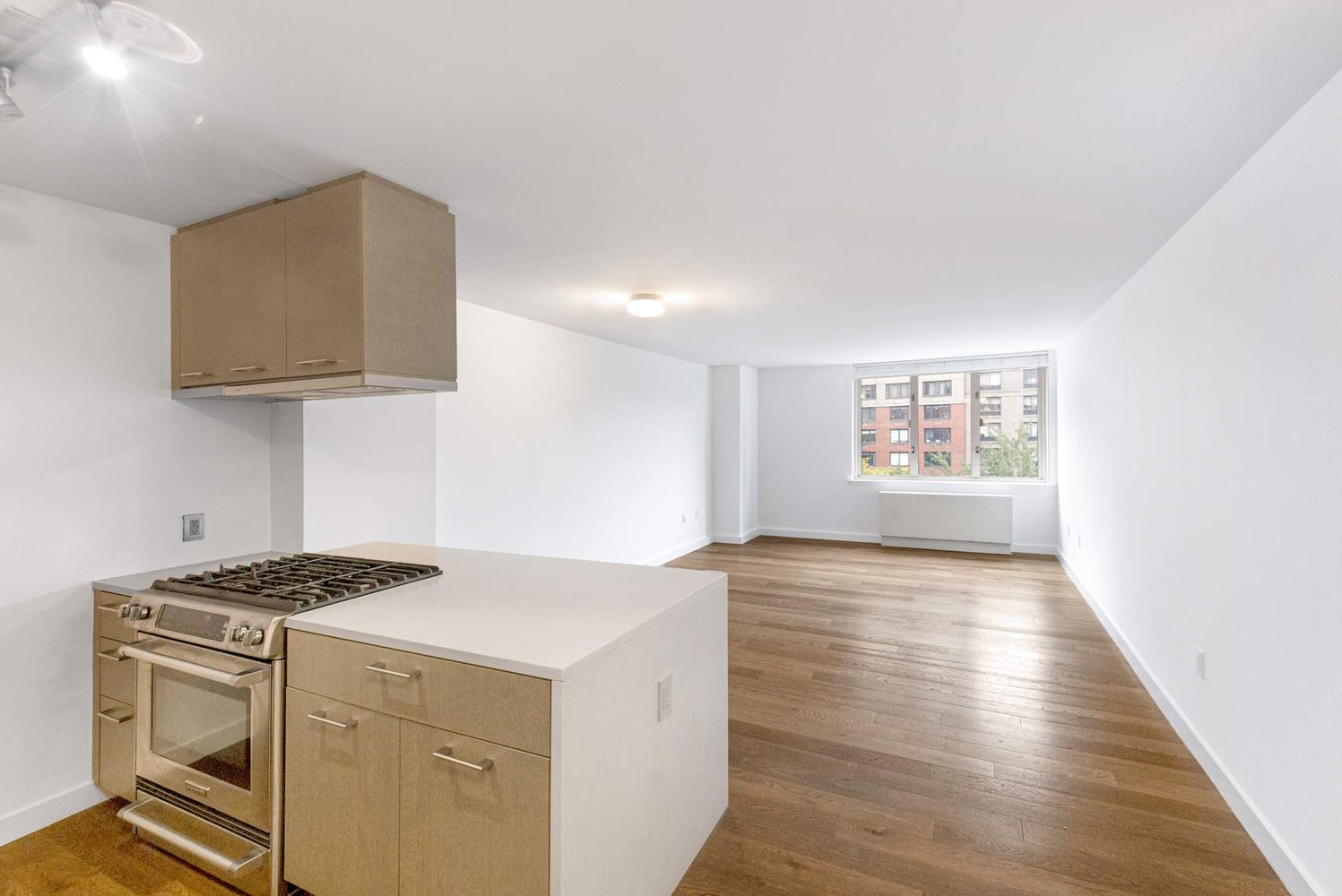 a kitchen with granite countertop a stove and a wooden floor