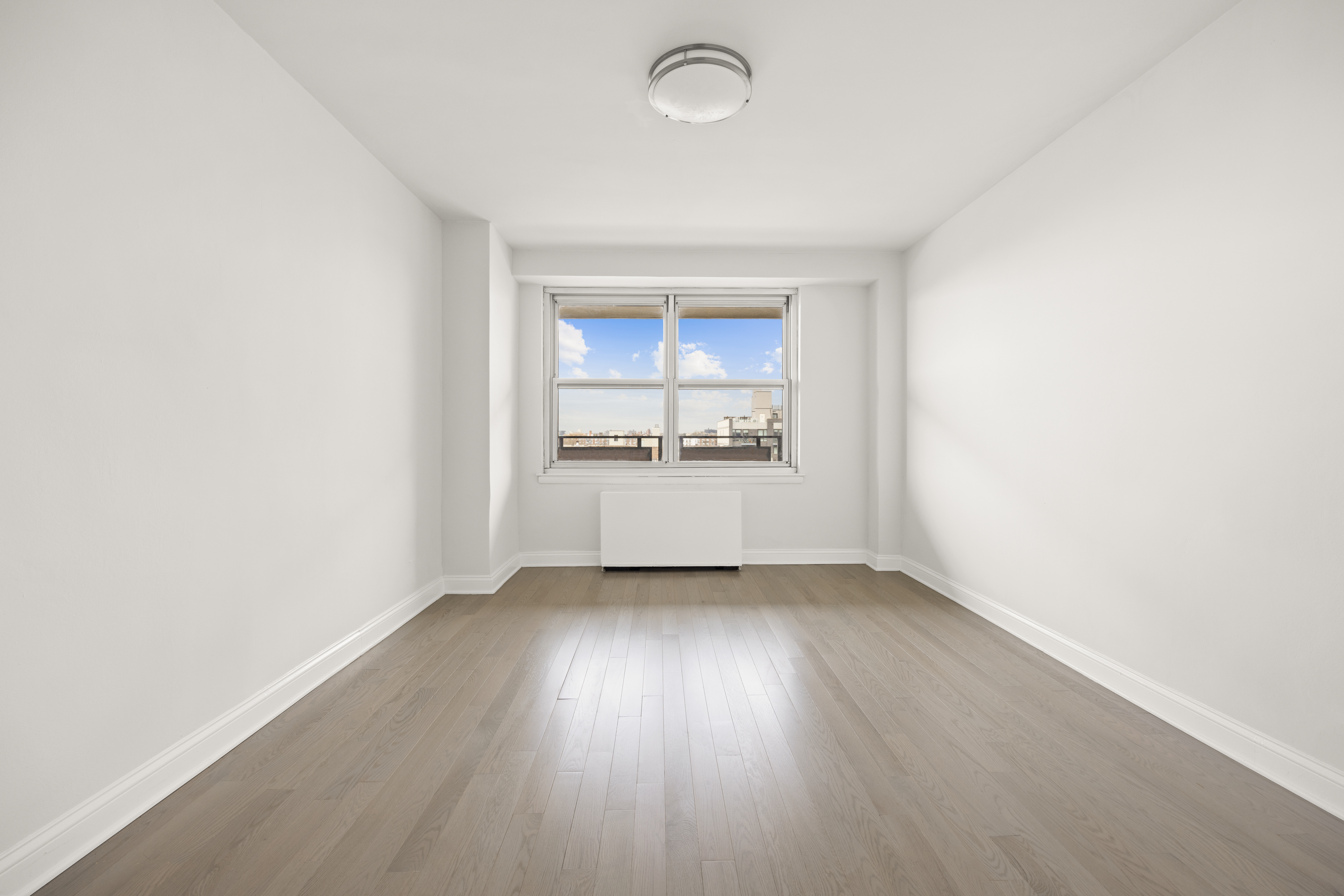 135 Ocean Parkway, Unit 9M Brooklyn, NY 11218 - Photo 16 of 18 an empty room with wooden floor and windows