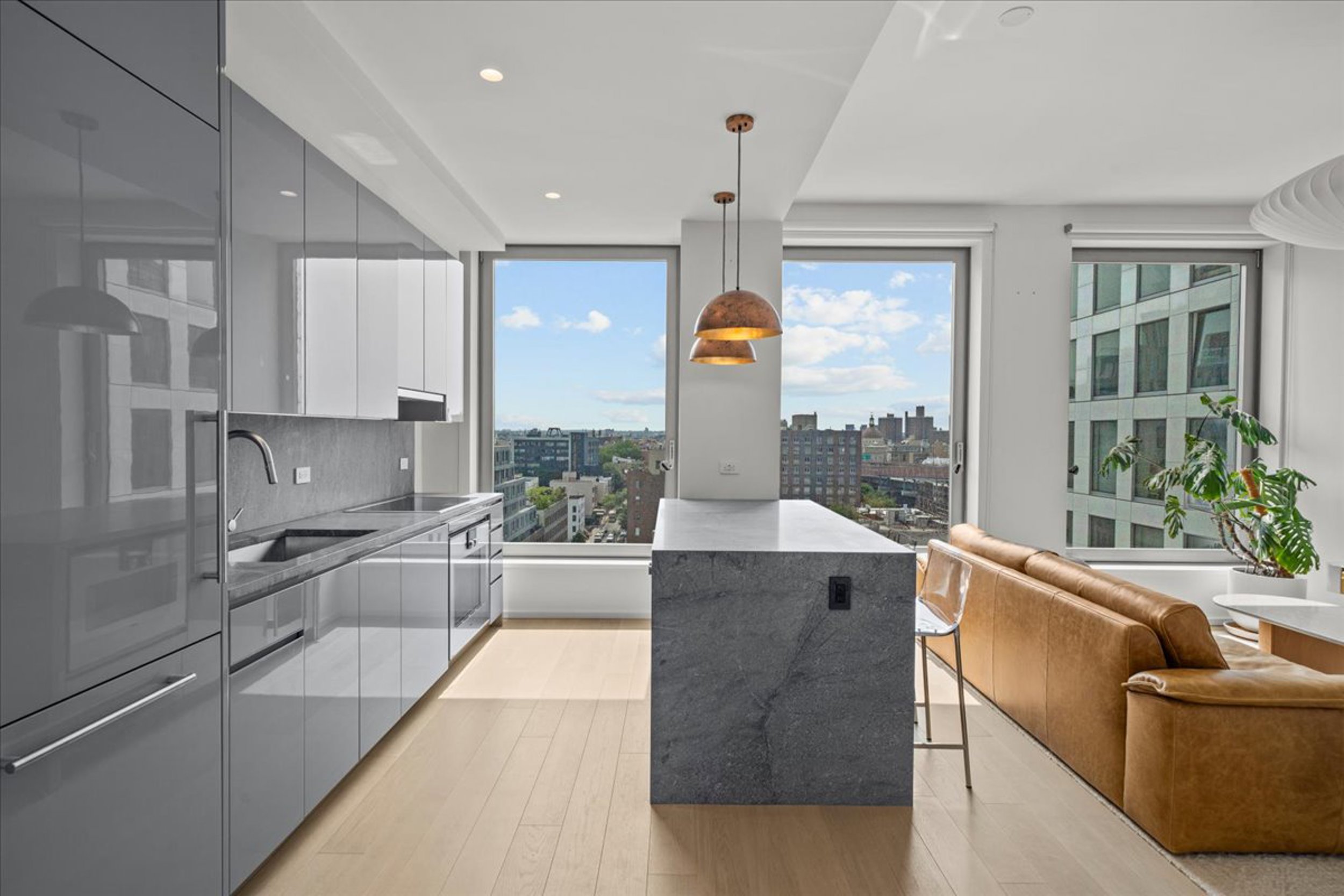 8 South 4th Street, Unit 15D Brooklyn, NY 11249 - Photo 2 of 29 a large kitchen with stainless steel appliances a large counter top a sink a stove and a refrigerator